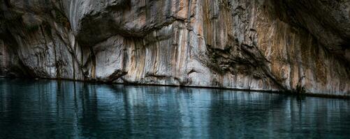chiaro blu acqua nel un' in profondità canyon con puro roccia muri foto