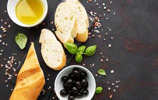 baguette fresche croccanti affettate con olive e spezie foto