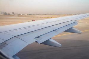 ala di aeroplano sulla pista dell'aeroporto di ben gurion all'alba foto