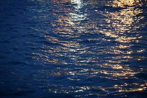 fasci di luce sull'acqua durante il crepuscolo foto