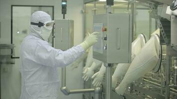 farmaceutico produzione linea lavoratore a opera. robotica braccio sollevamento ampolle a confezione linea nel farmaceutico fabbrica. farmaceutico industria. fiala confezione macchina foto