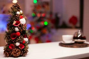 vicino su di Natale albero decorazioni nel festivo cucina progettato per di stagione cena festa. nessuno nel vuoto camera con illuminato inverno ornamenti, cucinando utensili e elettrodomestici foto