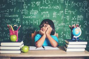 bambina premurosa con libro vicino a un consiglio scolastico foto