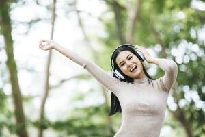 donna asiatica che ascolta la musica preferita sulle cuffie. tempo felice e relax. foto