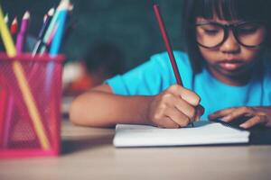 ragazza con disegno a pastello a lezione in classe foto