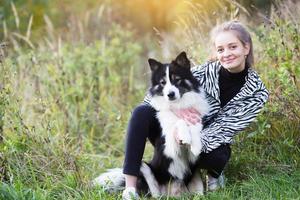 ragazza attraente seduta accanto al suo cane foto