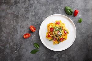 pasta con spinaci e parmigiano in un piatto su un tavolo grigio foto