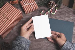 carta di carta dell'etichetta del modello con la decorazione di natale sul fondo di legno della tavola. foto