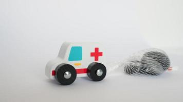 primo piano di un giocattolo di ambulanza che tira un carico pesante di pietre. concettuale per gli sforzi che stanno facendo i sistemi sanitari durante il covid foto