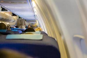 interno dell'aereo passeggeri con persone sui sedili foto