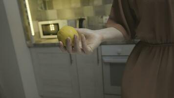 avvicinamento di donna Tenere Limone nel mano. azione. bellissimo donna detiene totale Limone nel mano per cucinando. donna detiene Limone prima cucinando foto