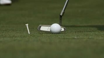 professionale giocatore mettendo palla in il buco. golf palla di il bordo di buco con giocatore nel sfondo su un' soleggiato giorno foto