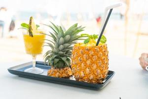 frullati di ananas con sfondo di spiaggia di mare foto