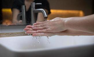 la bella mano femminile che applica sapone nel lavandino da o anti-batteri per prevenire la diffusione di germi a sfondo bianco foto