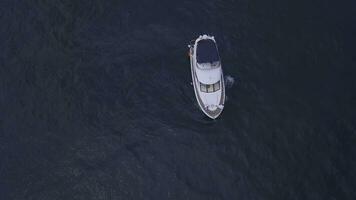 aereo superiore Visualizza di un' lusso bianca yacht e rilassante le persone. clip. concetto di estate vacanza, bellissimo vela barca crociera nel in profondità blu Egeo mare. foto