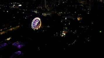 aereo notte Visualizza di città orizzonte e Ferris ruota. superiore Visualizza di Ferris ruota nel il centrale parco a notte. clip. foto
