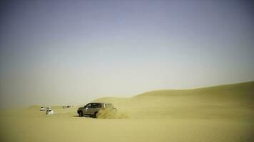 aereo Visualizza su fuori strada avventura con suv nel arabo deserto a tramonto con dubai orizzonte o paesaggio urbano. deserto turismo con suv. fuori strada suv equitazione nel il deserto. guida un' 4 ruote guidare suv su il foto