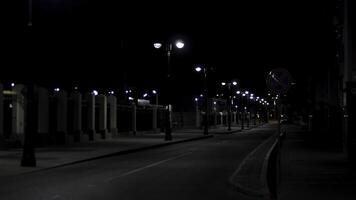 bellissimo e calma atmosfera di il estate notte nel grande città, buio strada con molti splendente lanterne. azione filmato. vuoto strada e marciapiede. foto