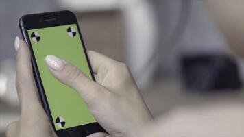 croma chiave schermo per posizionamento di il tuo proprio contenuto. azione filmato. donna mani con Perfetto manicure Tenere smartphone e scorrevole su il croma chiave verde schermo. foto