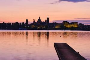 castello medievale e skyline della città illuminati al tramonto foto