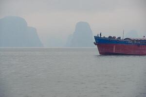 nebbioso viaggio - carico nave nel ah lungo baia foto