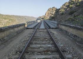 ponte ferroviario abbandonato attraverso le montagne. foto