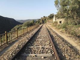 binari ferroviari abbandonati attraverso le montagne foto