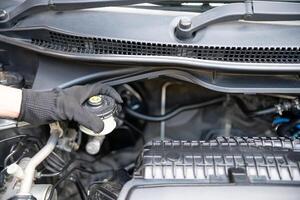 mano di tecnico controllo freno fluido nel motore camera Manutenzione e di base servizio concetto di il auto e freno sistema foto