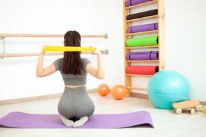 giovane donna è fare ginnastica nel palestra. salutare stile di vita. elastico allungamento foto