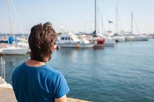 turista nel porto marittimo. yachts nel il parcheggio quantità, porto di mare nel Odessa, nero mare. andare in barca, ricco stile di vita, spiaggia vacanze. attività commerciale noleggio di Barche, equitazione turisti su il onde. soleggiato giorno, vento. vicino su foto