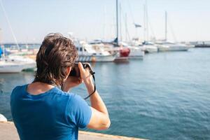 turista nel porto marittimo. yachts nel il parcheggio quantità, porto di mare nel Odessa, nero mare. andare in barca, ricco stile di vita, spiaggia vacanze. attività commerciale noleggio di Barche, equitazione turisti su il onde. soleggiato giorno, fotografo foto