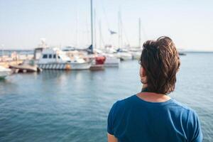 turista nel porto marittimo. yachts nel il parcheggio quantità, porto di mare nel Odessa, nero mare. andare in barca, ricco stile di vita, spiaggia vacanze. attività commerciale noleggio di Barche, equitazione turisti su il onde. soleggiato giorno, vento foto