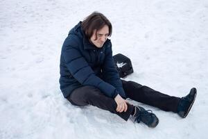 un' uomo cascate nel il neve. il uomo scivolato e era ferito. caduta su Ghiaccio. inverno. frattura, ammaccare, dislocazione. foto