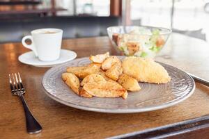 colazione, cena, pranzo nel un' ristorante, bar. al forno patate con Polpette, Cesare insalata, caffè Americano. intervistatore, delizioso cibo, grande finestre, naturale luce del sole. sfocato sfondo foto