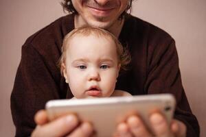 genitori con figlia Guardando video su mobile Telefono a casa foto