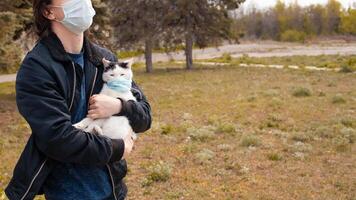 un' nero e bianca gatto nel un' medico maschera passeggiate su il strada foto