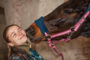 un' giovane ragazza baci un' cavallo. un' cavallo baci il suo padrona. foto