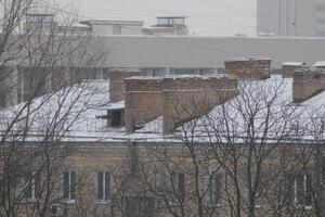 tetti e camini coperto con neve nel inverno foto