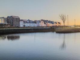 bellissimo Alba paesaggio urbano scenario di lungo camminare a claddagh nel galway città, Irlanda foto