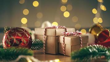 scatola regalo di natale o capodanno con rami di albero e decorazioni natalizie su tavola di legno, luci scintillanti di festa sullo sfondo del bokeh.