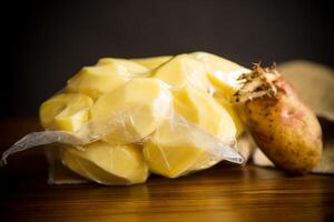 pelato patate chiuso nel un' vuoto Borsa e vecchio germogliato patate foto