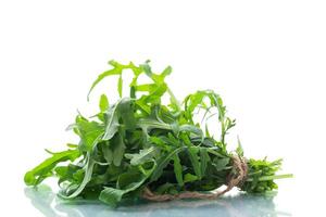 mazzo di fresco biologico verde rucola su bianca sfondo foto