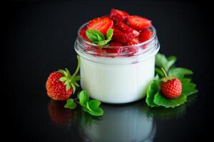 dolce fatti in casa Yogurt con fresco maturo fragole nel un' bicchiere vaso foto