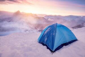 tenda campeggio su il picco con Alba al di sopra di montagna su inverno foto