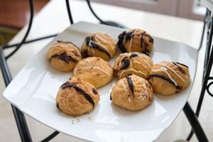 pasticcino o choux crema con sormontato cioccolato su bianca pianta foto