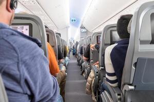 non identificato viaggiatori seduta su posti a sedere nel aereo foto