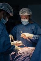 maschio chirurghi nel il operazione camera durante un' procedura foto