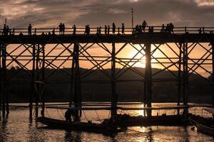 silhouette turisti viaggio a piedi su di legno lun ponte foto