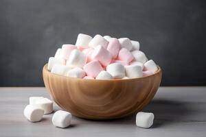 ai generato marshmallows su di legno ciotola, grigio sfondo foto