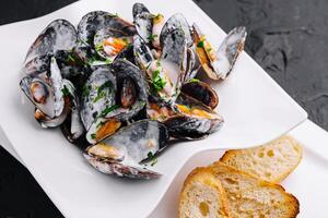 piatto di gustoso cozze con prezzemolo e tostato pane foto